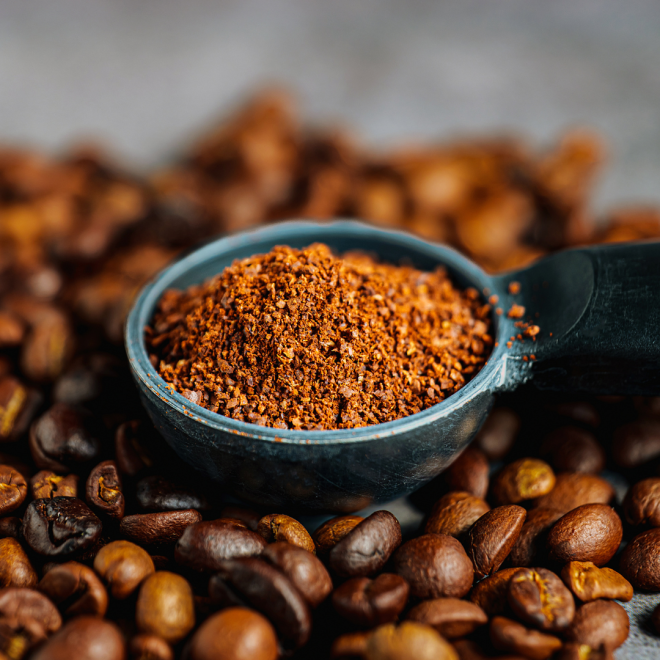 Kaffebönor och en matsked med malt kaffe