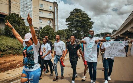 Unga människor går med protestskyltar i Nigeria.