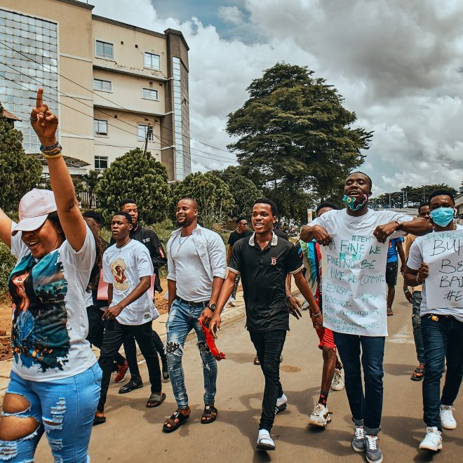 Unga människor går med protestskyltar i Nigeria.