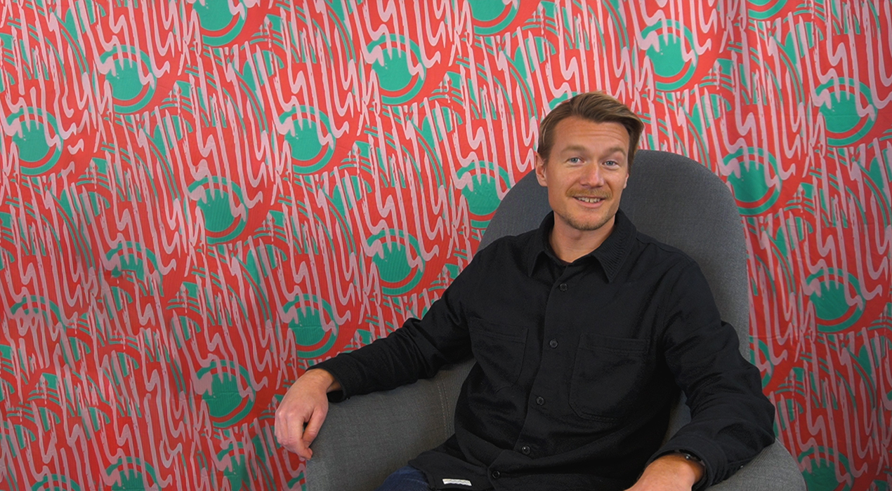 Pelle sitter i en grå fåtölj