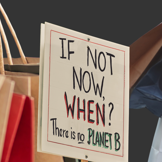 Stora shoppingpåsar bakom en skylt där det står "if not now, when? There is no planet b"