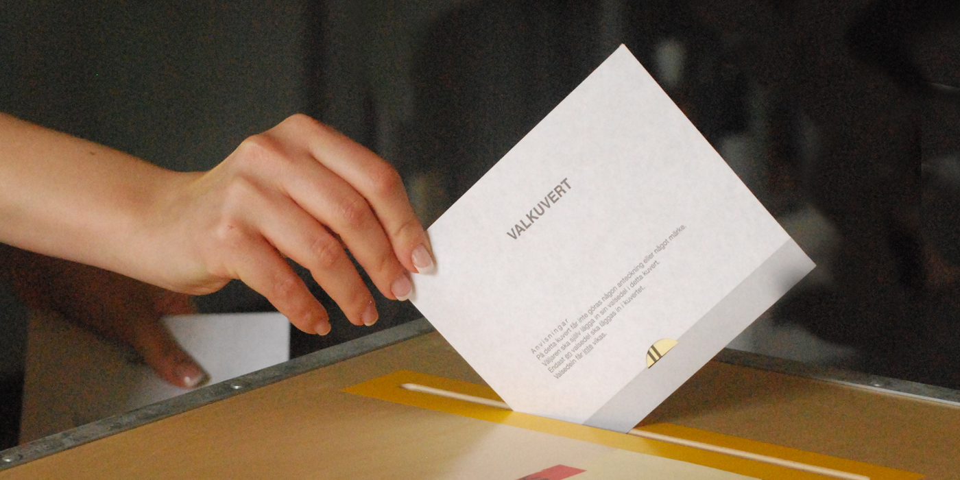 Valsedel som läggs i urna.