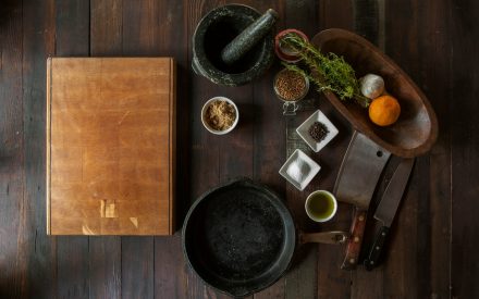 Skärbräda, mortel och kryddor på ett bord