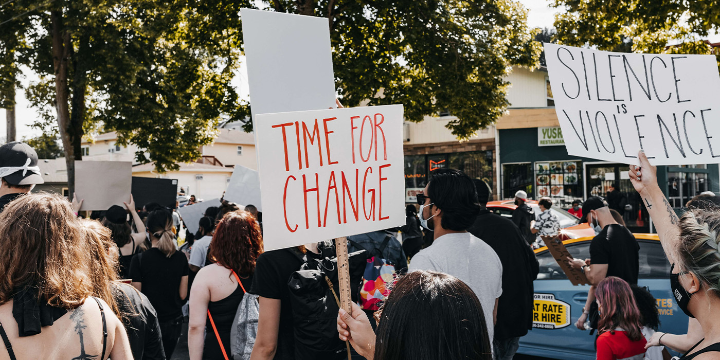 Demonstrant med protestskylt med texten time for change