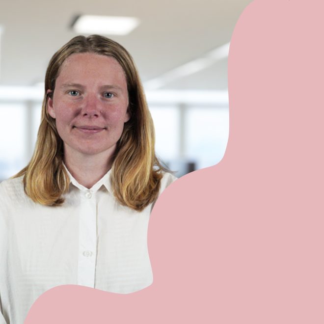Anna ler mot kameran i vit skjorta