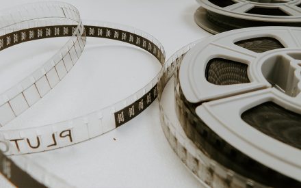 Filmremsor och filmrullar ligger utspridda på ett ljust bord.