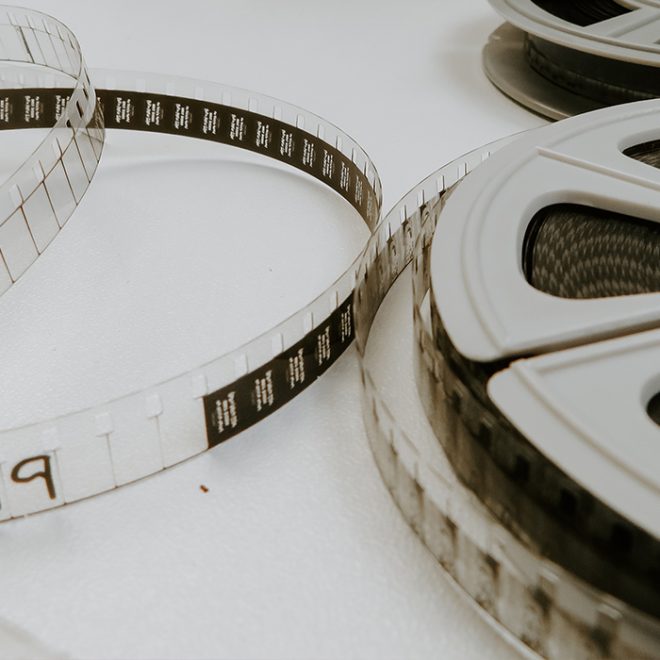 Filmremsor och filmrullar ligger utspridda på ett ljust bord.