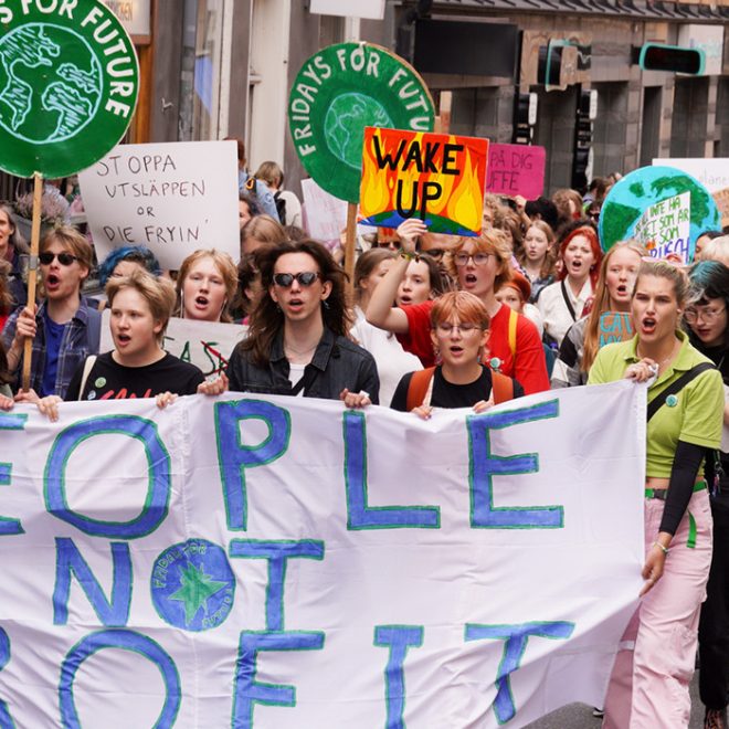 Klimatdemonstration. Människor går med banderollen People not profit.