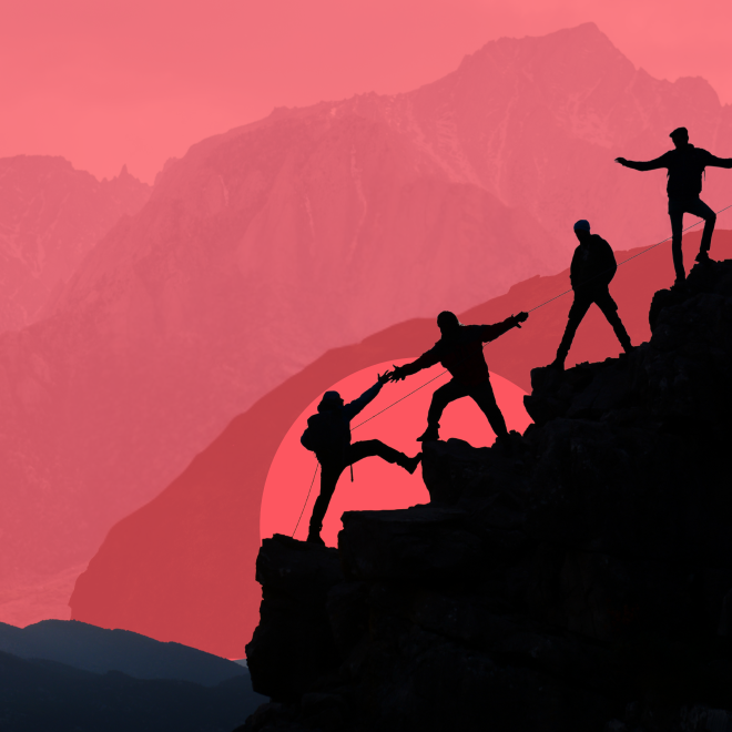 Fyra människor hjälper varandra uppför ett berg mot en rosaröd himmel.