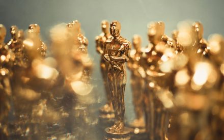 Flera oscarstatyeter står radade bredvid varandra alla är suddiga föruom en statuett i mitten som har skarp bildskärpa.