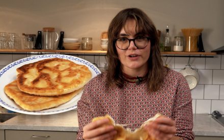 Amanda står i ett kök och håller i ett placinta bröd