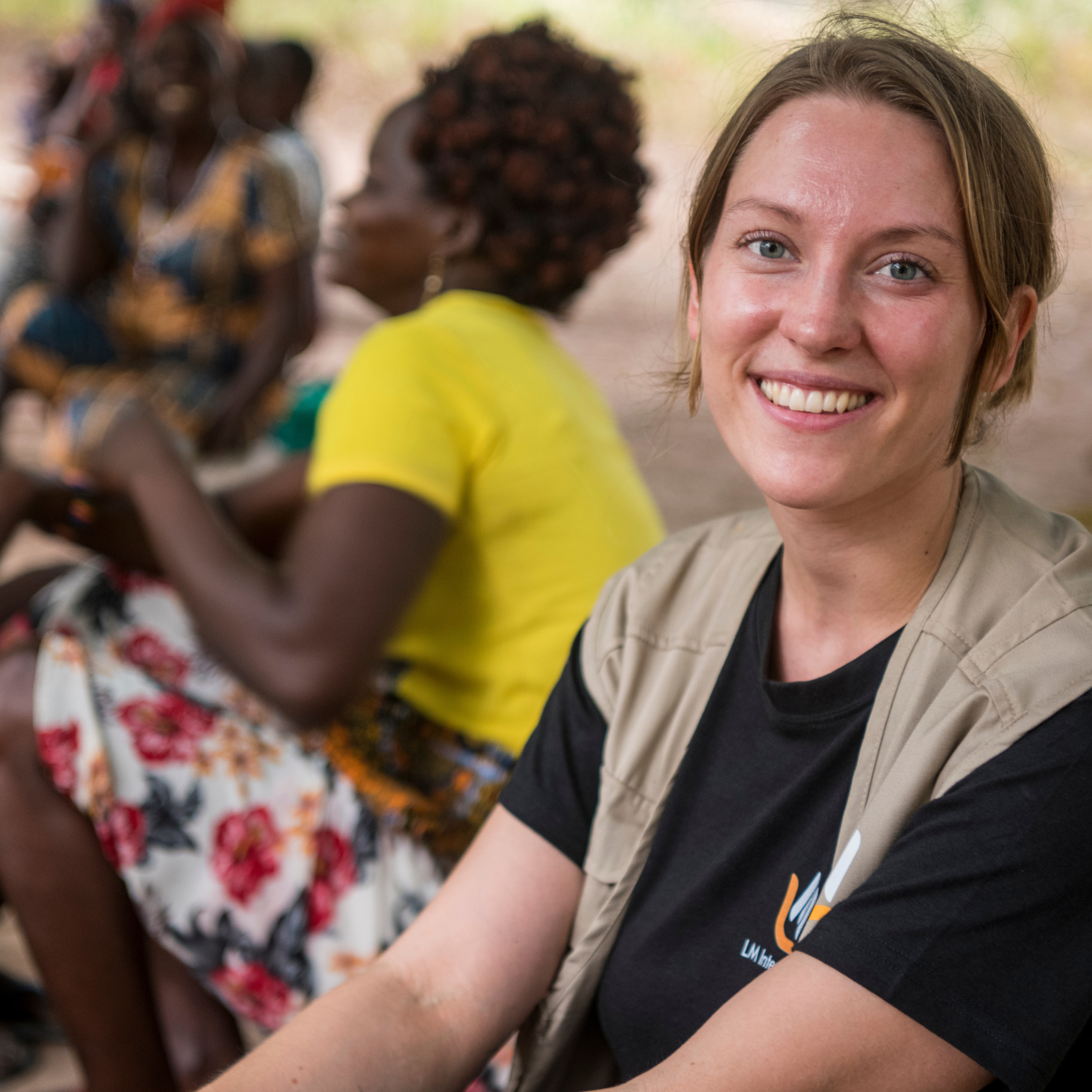 Kvinna i svart t-shirt och beige väst