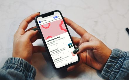 Kvinna håller i telefon. På skärmen visas Substack hemsida med Jobbtipsbrevet.