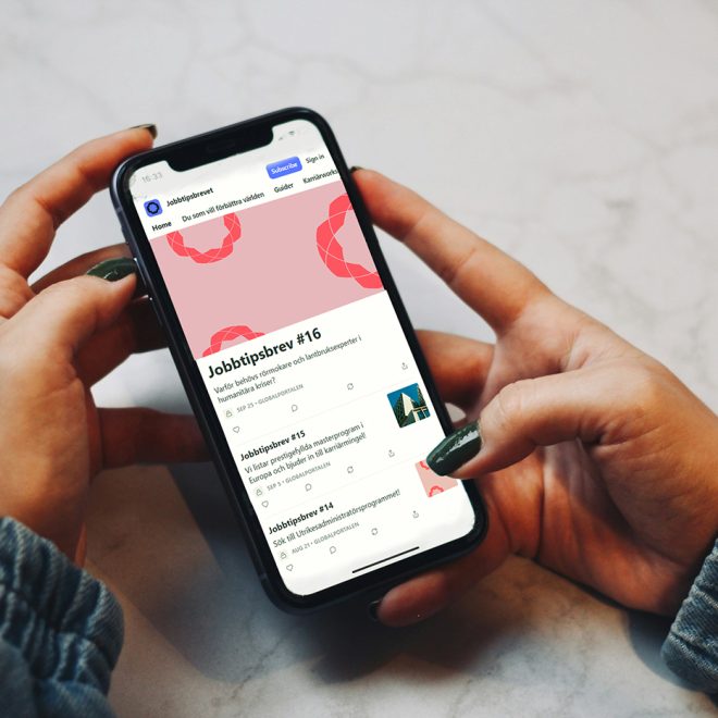 Kvinna håller i telefon. På skärmen visas Substack hemsida med Jobbtipsbrevet.