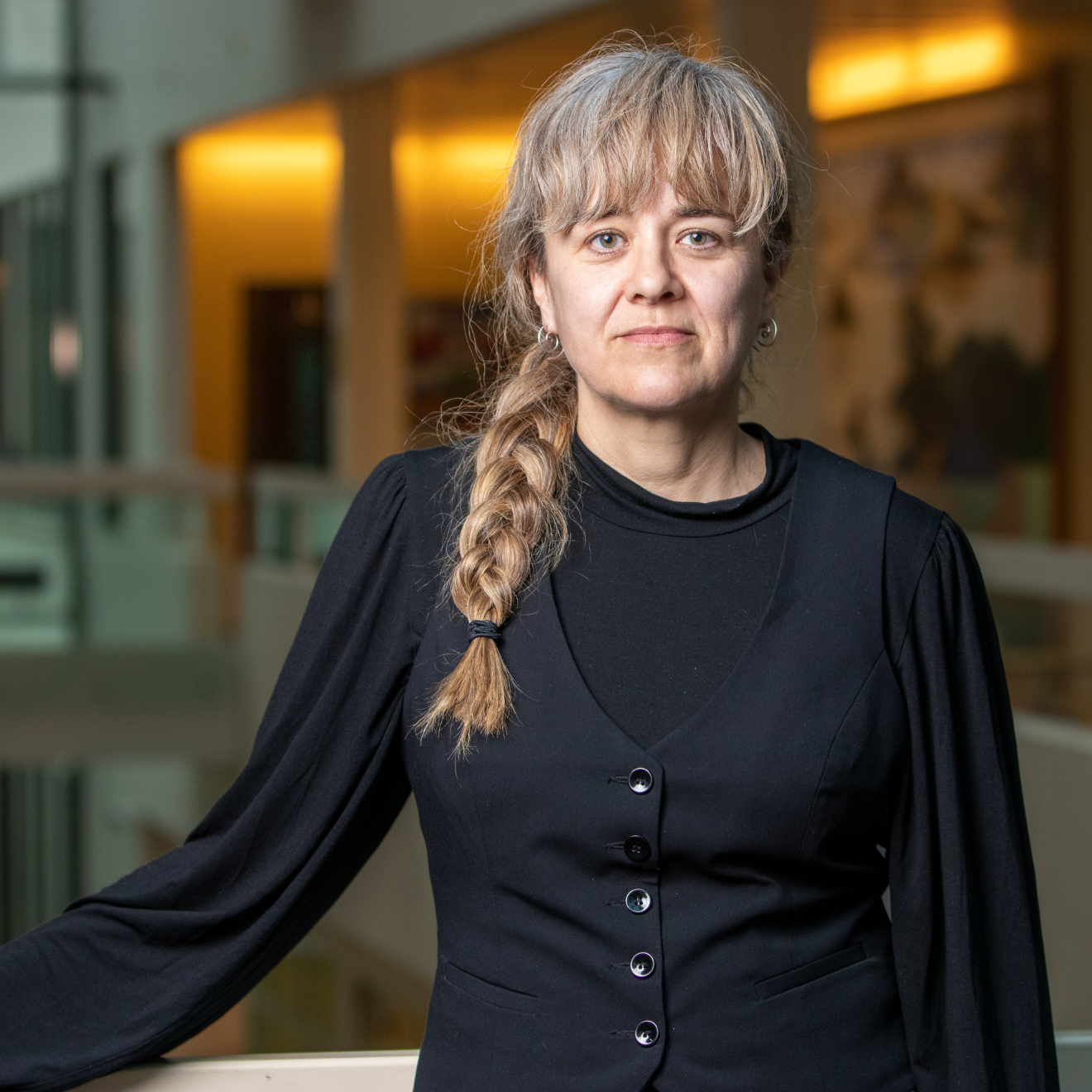 Kvinna i blus och svart väst