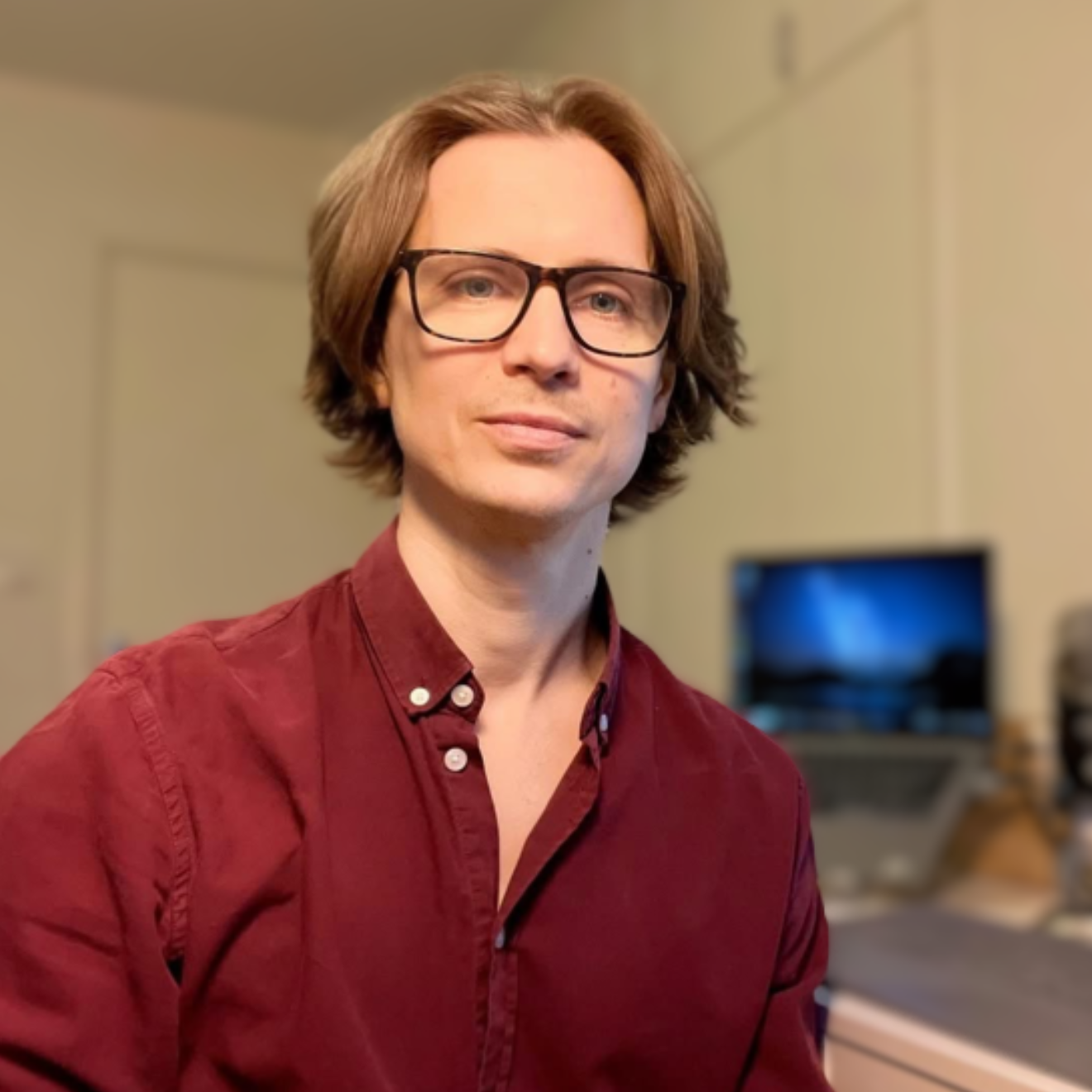 man i röd skjorta vid skrivbord