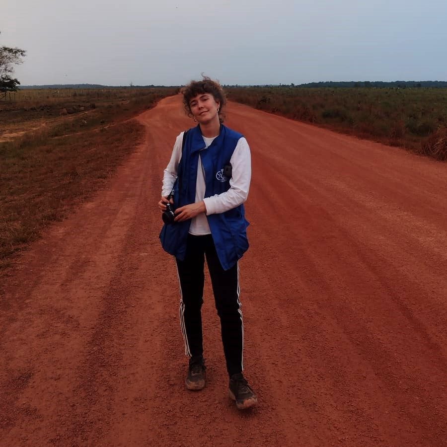 Jorunn iklädd blå väst står på en landsväg.