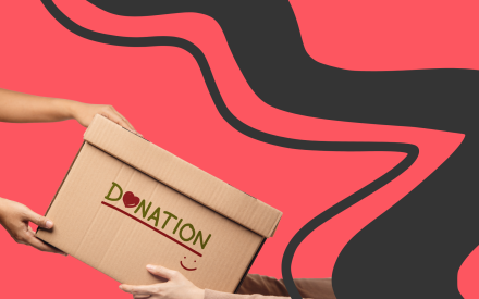 Bild på två personer som bär en låda med ordet donation på