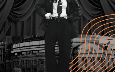 Person i kostym som står framför riksdagen. Svartvit bild.