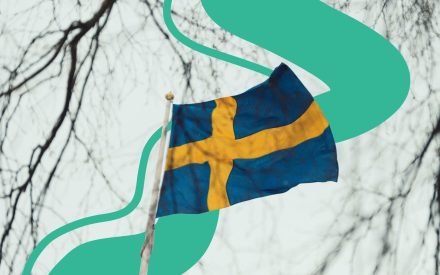 Svensk flagga mot en ljus himmel med grafiska gröna former i bakgrunden.