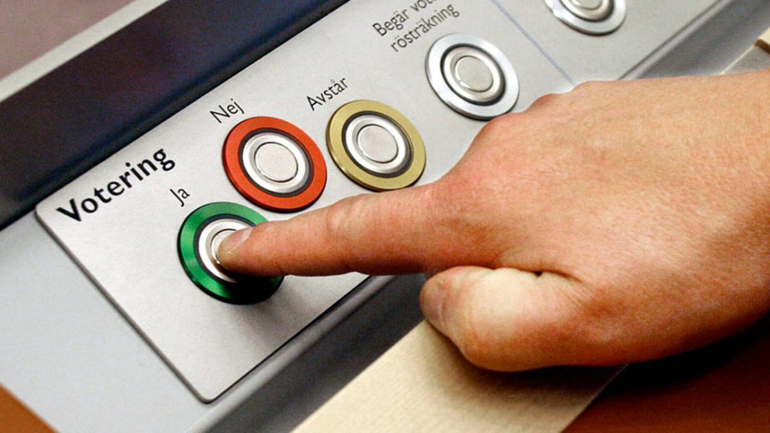 Voteringsknappar i riksdagen. Ja, nej, avstår.